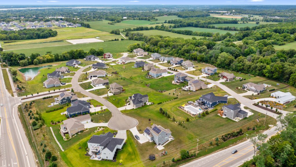 red fox crossing neighborhood overview with fields in background